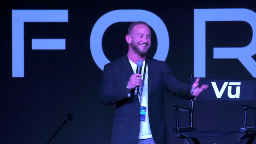 Eric Zhivalyuk Smiling and Speaking on Stage in Las Vegas at iHub Global and iHub Meta Event at Vu Studios ewoah